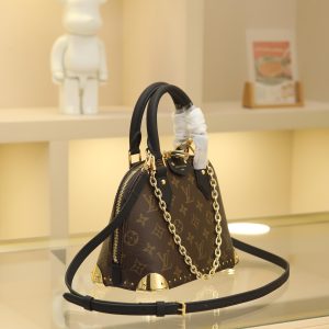 Alternative view of The Alma BB handbag has been reimagined as the newest addition to the Trunk collection, paying homage to the brand's rich heritage of travel with its iconic signature. Crafted from Monogram canvas, it features deep leather trim accented by dazzling metal corners and studs. This version comes with a detachable chain that can be worn with the adjustable shoulder strap or separately.19 x 11 x 22 cm (H x W x L) Monogram coated canvas Cowhide leather trim Fabric lining Metal hardware Zip closure with padlock and key Interior pocket accommodates 6.7-inch smartphone, earphones, Rosalie coin purse, keys, and lipstick Shoulder strap:Removable, adjustable Strap half-length: 50.0 cm Strap half-length adjustable to: 66.0 cm Chain: Removable chain Half-length: 22.0 cm Handles: Double handles